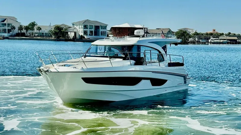 Slide: The Image of Bow View of Antares 11 on Water This image showcases the sleek bow of the 2022 Beneteau Antares 11, gliding effortlessly on the water. The modern hull design, characterized by its sharp lines and glossy finish, ensures both style and performance. Expansive windows on the cabin offer pan - 7403698