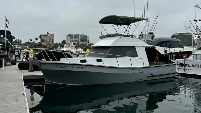 Slide: The Image of Port Side View of Flybridge Sportfish The 2019 Donelle 36 Flybridge Sportfish, BEAR FLAG III, is captured docked, showcasing its sleek hull and spacious flybridge. The vessel's classic design features a streamlined profile and a well-appointed flybridge with a protective canopy. Its robust co - 7398012