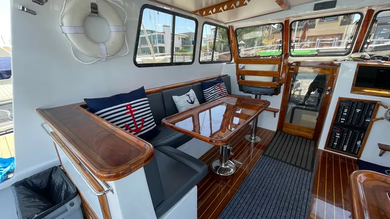 Slide: The Image of Spacious Interior Salon with Seating The interior salon of the 2019 Donelle 36 Flybridge Sportfish showcases a welcoming seating area with plush cushions and nautical-themed decor. Rich wood finishes and polished flooring add a touch of elegance, while large windows provide ample natural lig - 7397999