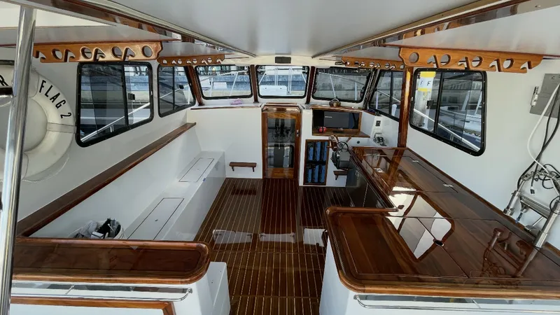 Slide: The Image of Spacious Interior with Helm Station The interior of the BEAR FLAG III features a well-appointed helm station with a comprehensive navigation setup. Rich wooden accents complement the sleek design, enhancing the vessel's luxurious feel. Large windows provide ample natural light and panoramic - 7397993