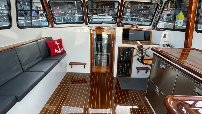Slide: The Image of Flybridge Interior with Helm Station The interior of the Donelle 36 Flybridge Sportfish showcases a sleek helm station equipped with modern navigation controls and a comfortable captain's chair. The space is accented by polished wood finishes and ample natural light pouring in through the la - 7397992