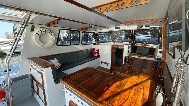 Slide: The Image of Flybridge Helm and Seating Area The flybridge of the 2019 Donelle 36 Flybridge Sportfish features a spacious helm with rich wood finishes and modern navigational instruments. A comfortable seating area with plush cushions and nautical decor provides an inviting space for relaxation. Exp - 7397994