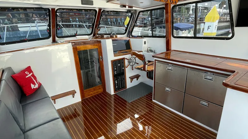 Slide: The Image of Spacious Flybridge Interior with Helm The flybridge interior of the 2019 Donelle 36 Flybridge Sportfish showcases a well-appointed helm with classic wooden accents and modern navigation equipment. Ample seating is provided with a sleek bench, complemented by elegant cabinetry and a polished w - 7397991