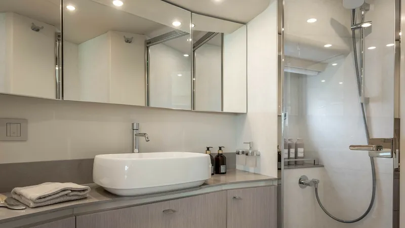 Slide: The Image of Luxurious Bathroom with Walk-In Shower This elegant bathroom on the 2027 Absolute Navetta 50 features a modern design with a spacious walk-in shower. The sleek vanity is complemented by mirrored cabinetry, offering ample storage and a sophisticated look. Subtle lighting enhances the serene atm - 7514473