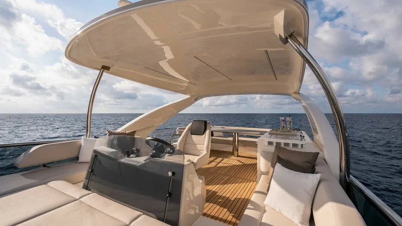 Slide: The Image of Flybridge with Helm and Lounge Seating Experience luxury on the flybridge of the 2027 Absolute Navetta 50, featuring a sleek helm station for seamless navigation. The spacious lounge area offers plush seating and a beautifully crafted teak deck, perfect for relaxation and entertaining. Enjoy p - 7514467