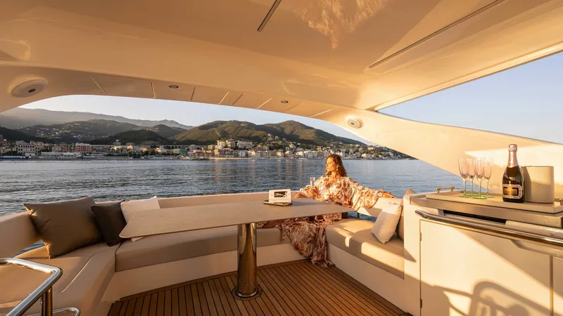 Slide: The Image of Spacious Aft Deck Lounge Area The aft deck of the 2027 Absolute Navetta 50 showcases a luxurious seating area with plush cushions, perfect for relaxation and entertaining. The elegant teak flooring adds a touch of sophistication, while the panoramic views provide a stunning backdrop. - 7514469