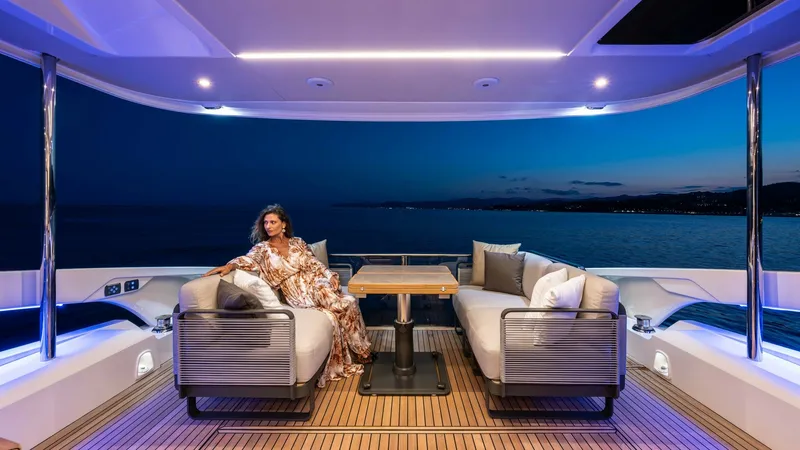 Slide: The Image of Elegant Aft Deck Lounge Area The aft deck of the 2027 Absolute Navetta 50 offers a luxurious lounging space with plush seating and a sleek teak finish. Enhanced by ambient lighting, this area provides a serene setting for relaxation while enjoying panoramic sea views. The modern desi - 7514479