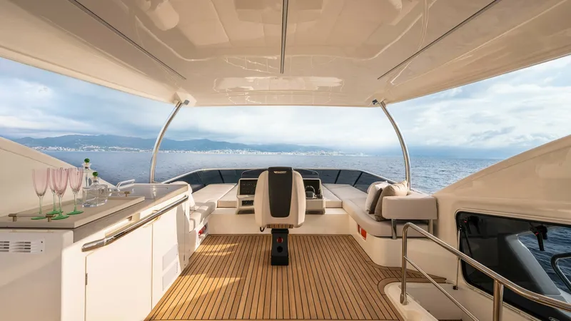 Slide: The Image of Flybridge with Helm and Seating Area The flybridge of the 2027 Absolute Navetta 50 offers a spacious and elegant outdoor living space. It features a central helm station with panoramic views, surrounded by plush seating for relaxation. The teak decking and sleek, modern design elements add t - 7514468