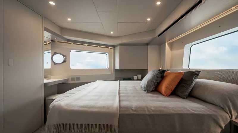 Slide: The Image of Luxurious Master Stateroom The master stateroom of the 2027 Absolute Navetta 50 exudes elegance with its spacious layout and panoramic windows, offering breathtaking ocean views. The plush bedding and tasteful décor create a serene and inviting atmosphere, while the integrated lig - 7514472