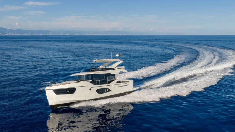 Slide: The Image of Exterior Side View in Motion The 2027 Absolute Navetta 50 showcases a sleek and modern design as it glides effortlessly through open waters. The clean lines and elegant profile are complemented by large windows offering panoramic views. This vessel's performance is highlighted by its - 7514485