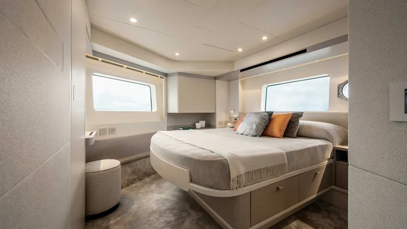 Slide: The Image of Luxurious Master Stateroom The master stateroom of the 2027 Absolute Navetta 50 exudes elegance and comfort, featuring a spacious layout with panoramic windows offering stunning views. The sophisticated design includes a plush bed adorned with premium linens and accent pillows, com - 7514470