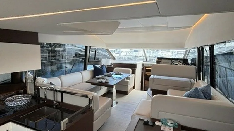 Slide: The Image of Spacious Interior Salon with Helm The 2024 Prestige 520 Flybridge features an expansive interior salon, showcasing luxurious seating and modern finishes. Large windows provide panoramic views, enhancing the open and airy feel of the space. The helm station is conveniently integrated, allo - 7455389