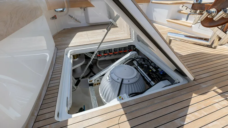 Slide: The Image of Engine Room Access Hatch The image showcases the open engine room access hatch on the Viking 74 Convertible's deck. The hatch reveals a well-organized space, highlighting advanced equipment and clean installations, ensuring easy maintenance and optimal performance. The teak decki - 7531194