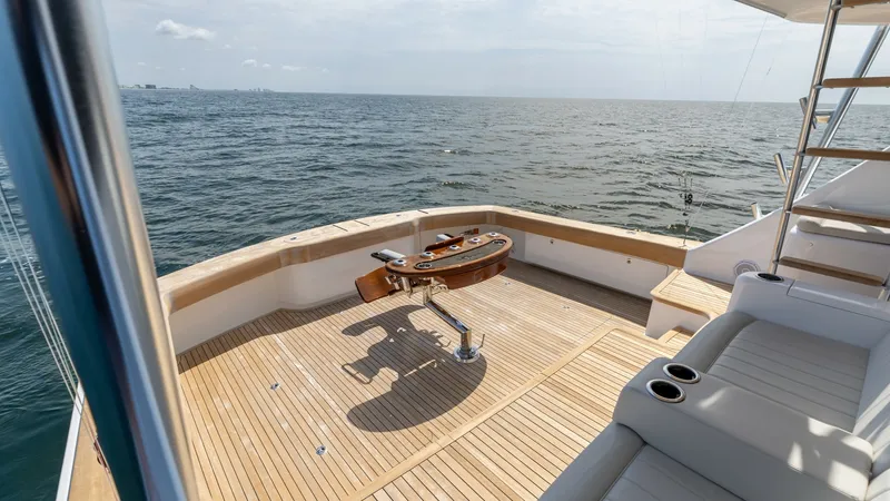Slide: The Image of Spacious Aft Deck with Fighting Chair The aft deck of the Viking 74 Convertible features a beautifully crafted teak floor, providing a luxurious outdoor space for relaxation and fishing. A polished fighting chair is centrally positioned, ideal for the avid angler, while built-in seating with - 7531189