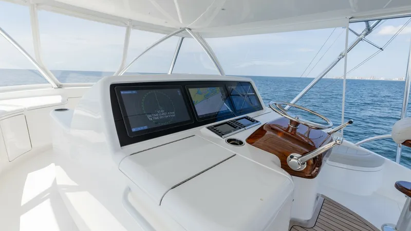 Slide: The Image of Flybridge Helm Station The flybridge helm station of the 2025 Viking 74 Convertible showcases sleek navigation technology with dual large-screen displays for optimal marine navigation. The polished teak finish on the steering area adds a touch of elegance, complemented by the e - 7531198