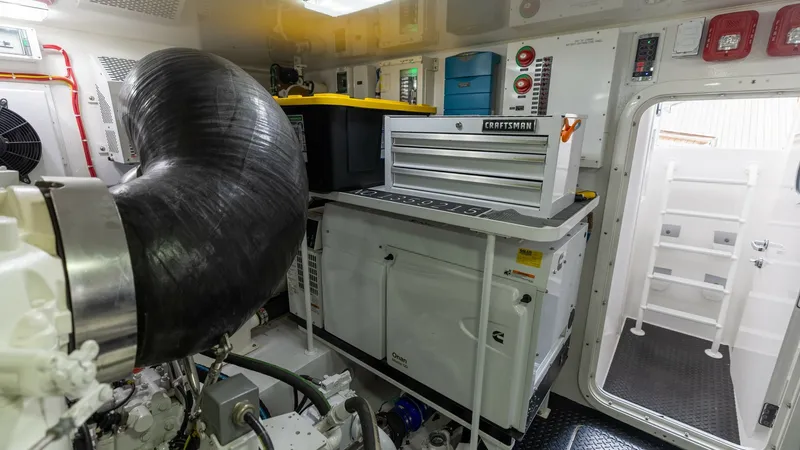 Slide: The Image of Engine Room with Workbench This image showcases the well-organized engine room of the 2025 Viking 74 Convertible, featuring a Craftsman workbench and ample storage. The space is equipped with high-quality equipment and visible control panels, offering easy access for maintenance. T - 7531187