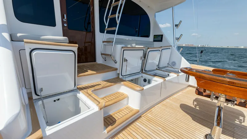 Slide: The Image of Aft Deck with Storage and Seating This image showcases the aft deck of the 2025 Viking 74 Convertible, highlighting its ample storage compartments and inviting seating area. The teak flooring adds a touch of elegance, while the ladder provides easy access to the upper levels. Perfectly de - 7531193