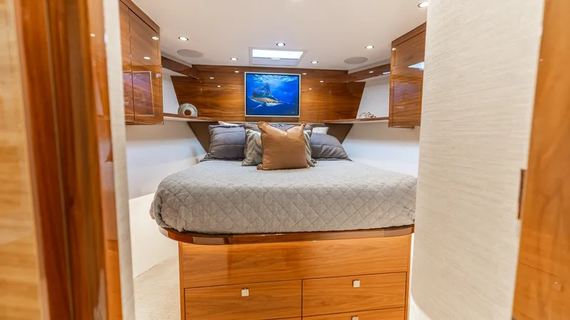 Slide: The Image of Luxurious Forward Stateroom This elegant forward stateroom features a plush queen-sized bed adorned with soft linens and decorative pillows, promising comfort and relaxation. The warm wooden cabinetry provides ample storage, while the overhead skylight and recessed lighting enhance - 7531171