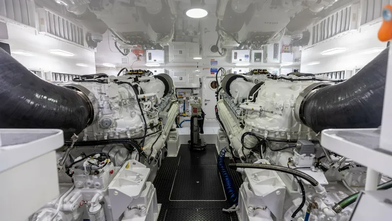 Slide: The Image of Engine Room with Twin Engines The engine room of the 2025 Viking 74 Convertible showcases twin powerful engines, expertly arranged for optimal performance and maintenance access. The space is well-lit, emphasizing the pristine condition and advanced engineering of the vessel. The clea - 7531184