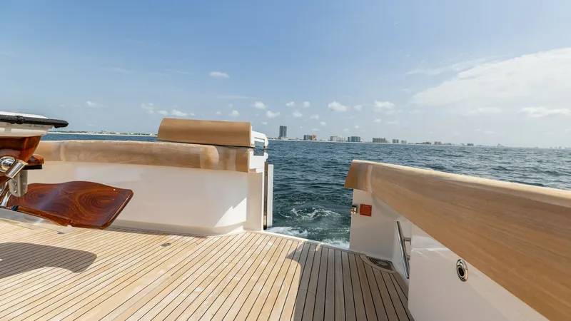Slide: The Image of Spacious Aft Deck with Ocean View The aft deck of the 2025 Viking 74 Convertible offers an expansive teak flooring that beautifully complements the open sea views. Featuring elegant wood finishes and a robust fishing chair, this area is designed for both relaxation and functionality. The - 7531191