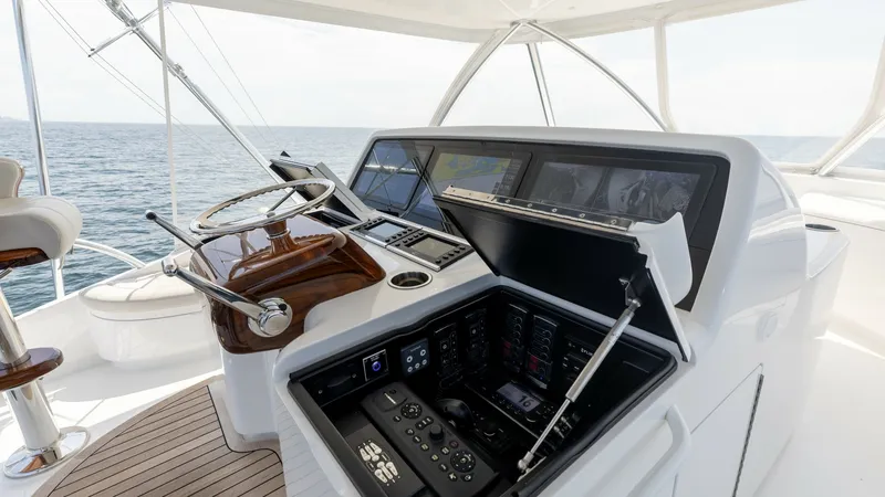 Slide: The Image of Flybridge Helm Station This image showcases the sleek and modern helm station on the flybridge of the 2025 Viking 74 Convertible. Featuring state-of-the-art navigation displays and a polished wood steering wheel, the helm offers a commanding view of the open sea. The ergonomic - 7531201