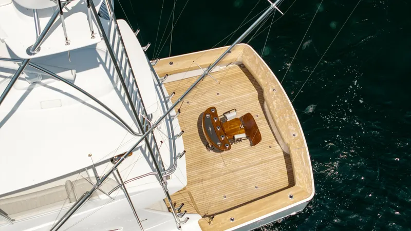 Slide: The Image of Aerial View of Aft Deck This stunning aerial view showcases the aft deck of the 2025 Viking 74 Convertible 'It Just Takes Time.' The spacious teak deck provides an elegant and durable surface, ideal for fishing or relaxation. Centered on the deck is a high-quality fighting chair - 7531206
