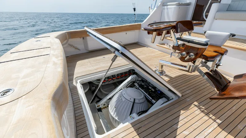 Slide: The Image of Aft Deck with Engine Access Hatch The aft deck of the 2025 Viking 74 Convertible showcases a practical engine access hatch, seamlessly integrated into the teak flooring. This feature provides convenient maintenance access while maintaining the aesthetic appeal of the deck. The surrounding - 7531195