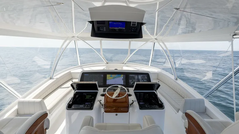 Slide: The Image of Flybridge Helm with Panoramic View The helm of the Viking 74 Convertible offers a commanding view with its elevated flybridge position. Featuring state-of-the-art navigation systems and luxurious teak accents, this area combines functionality with elegance. Plush seating ensures comfort wh - 7531200