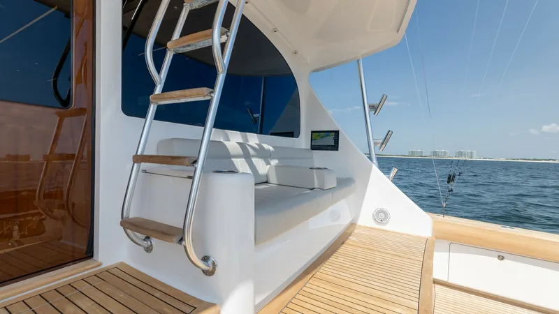 Slide: The Image of Sleek Aft Deck with Ladder Access This image showcases the elegant aft deck of the Viking 74 Convertible, featuring a polished teak deck and comfortable seating area. The stainless steel ladder provides easy access to the upper levels, while the sleek design and panoramic views offer a pe - 7531188