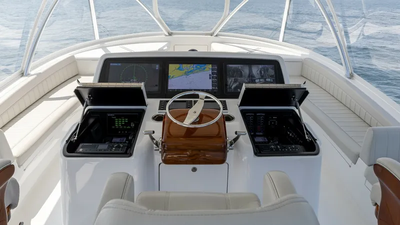 Slide: The Image of Flybridge Helm with Electronics Suite The flybridge helm of the 2025 Viking 74 Convertible boasts a state-of-the-art electronics suite, featuring multiple high-resolution displays for navigation and monitoring. The sleek wooden steering console is complemented by advanced control panels house - 7531199