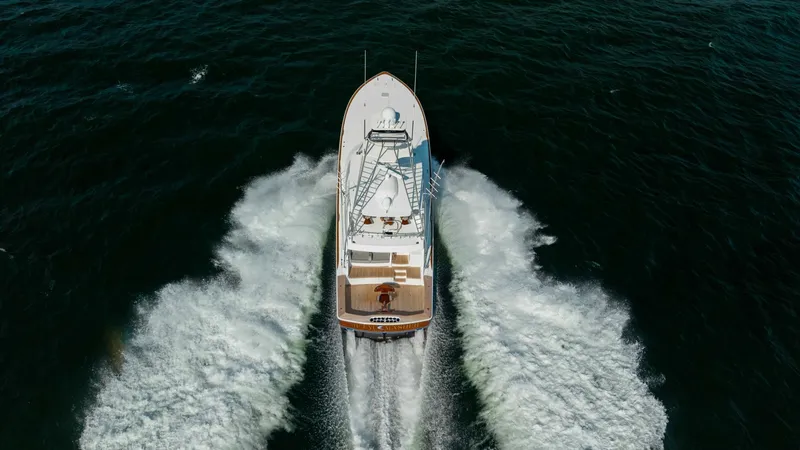 Slide: The Image of Aerial View of Running Yacht This striking aerial shot captures the 2018 Viking 72 Convertible, Metal Masher, powering through the open water. The vessel's sleek design and robust performance are highlighted by the dynamic wake it creates. The spacious deck and flybridge are visible, - 7460632