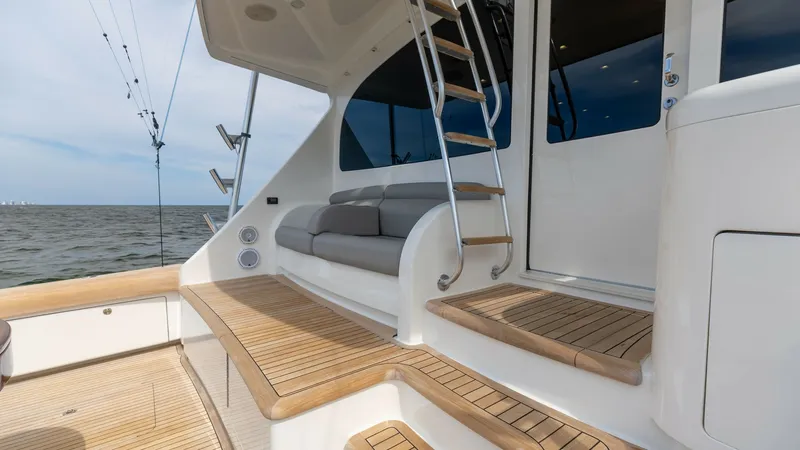 Slide: The Image of Aft Deck with Seating and Ladder The aft deck of the 2018 Viking 72 Convertible showcases a spacious seating area with plush cushions, ideal for relaxation while cruising. The teak flooring adds a touch of elegance, complemented by a sleek ladder leading to the upper deck. This outdoor s - 7460608