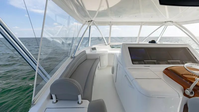 Slide: The Image of Flybridge Helm Station with Seating The flybridge of the 2018 Viking 72 Convertible showcases a well-appointed helm station with state-of-the-art navigation equipment. The spacious seating area provides comfort and panoramic views, ideal for navigating open waters. The sleek design and high - 7460614