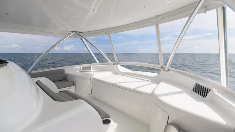 Slide: The Image of Flybridge Lounge Area with Ocean View Experience unparalleled comfort in the flybridge lounge of the 2018 Viking 72 Convertible. This spacious area features sleek, cushioned seating and large windows offering panoramic ocean views. The sophisticated design and high-quality materials make it a - 7460615