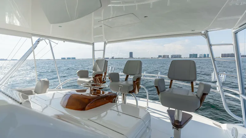 Slide: The Image of Flybridge Helm with Seating This spacious flybridge helm on the 2018 Viking 72 Convertible offers a commanding view of the open water. Featuring plush, ergonomic captain's chairs, the area is designed for both comfort and functionality. The sleek design and high-quality finishes emp - 7460610