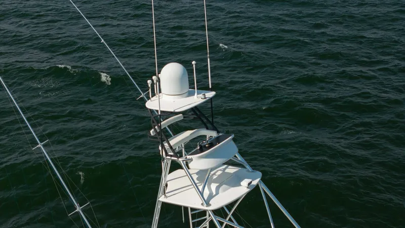 Slide: The Image of Tuna Tower with Electronics The image showcases the sophisticated tuna tower on the 2018 Viking 72 Convertible, Metal Masher. This elevated platform is equipped with advanced navigation and communication systems, providing an exceptional vantage point for spotting fish. The sleek de - 7460622