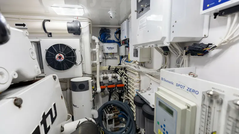Slide: The Image of Engine Room Systems Overview This image showcases the meticulously organized engine room of the 2018 Viking 72 Convertible, featuring state-of-the-art systems. Prominent components include a Dometic Spot Zero water filtration system, advanced ventilation, and control panels, ensuring - 7460600