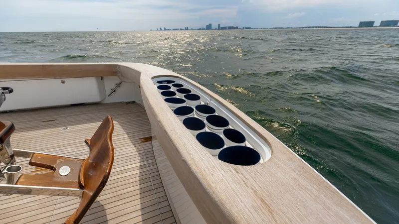 Slide: The Image of Aft Deck Fishing Setup The aft deck of the 2018 Viking 72 Convertible showcases a well-equipped fishing station with multiple rod holders integrated into the gunwale. The teak decking exudes luxury and provides durability for serious anglers. The expansive view of the open wate - 7460606