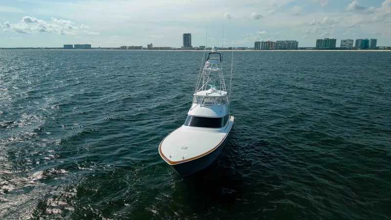Slide: The Image of Aerial Bow View at Sea This image captures the Viking 72 Convertible slicing through open waters, showcasing its sleek and powerful design. The vessel's sharp bow and towering flybridge are highlighted against the expansive ocean backdrop, demonstrating its capability and elega - 7460625