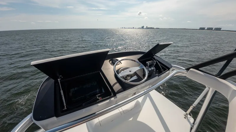 Slide: The Image of Flybridge Helm Station View The helm station on the flybridge of the 2018 Viking 72 Convertible provides an elevated vantage point with state-of-the-art navigation equipment. Featuring dual display screens and a sleek, modern steering wheel, this area ensures precise control and vis - 7460620
