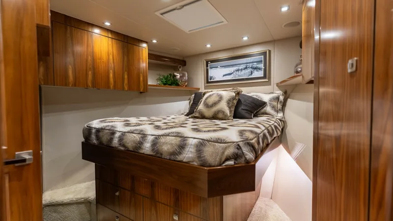 Slide: The Image of Luxurious Guest Stateroom This inviting guest stateroom on the Viking 72 Convertible features a plush double bed adorned with stylish bedding. Rich wood cabinetry provides ample storage, while overhead LED lighting creates a warm and welcoming ambiance. The modern decor, including - 7460588