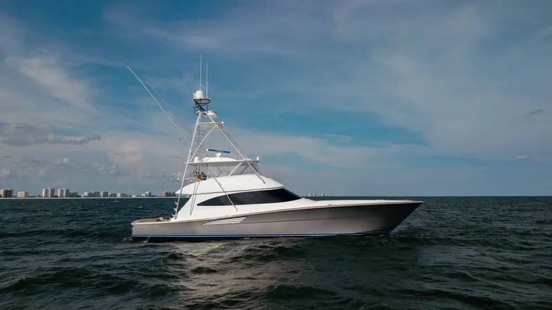 Slide: The Image of Side Profile of Viking 72 Convertible This image showcases the sleek and powerful side profile of the 2018 Viking 72 Convertible, known as Metal Masher. The vessel's aerodynamic lines and robust hull design are highlighted against a serene ocean backdrop. Its tower and outriggers are prominen - 7460624