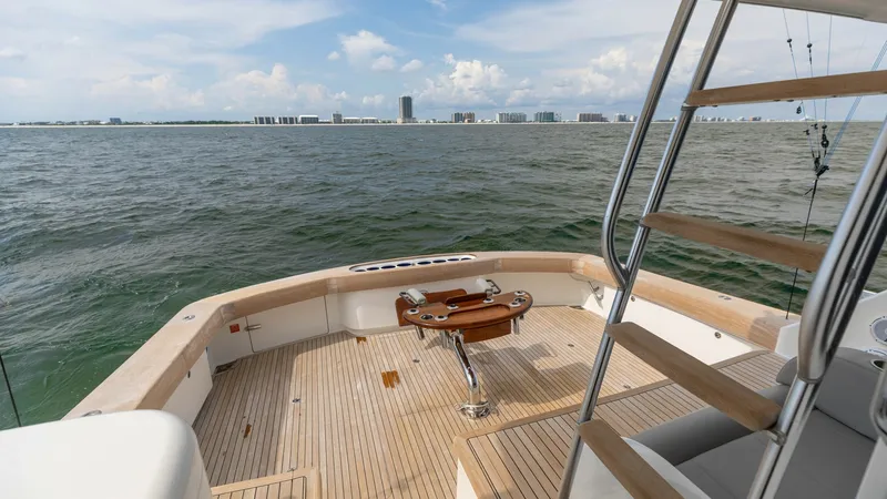 Slide: The Image of Spacious Aft Deck with Fishing Chair This aft deck of the 2018 Viking 72 Convertible offers a generous teak-finished space ideal for fishing enthusiasts. Featuring a centrally positioned fishing chair, the area is designed for both functionality and comfort. The open layout provides stunning - 7460607