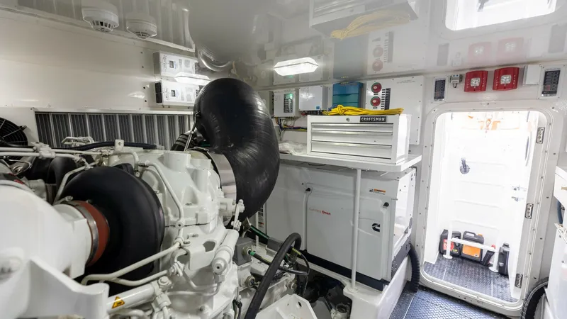 Slide: The Image of Engine Room with Access Door The engine room of the 2018 Viking 72 Convertible features a meticulously organized layout with state-of-the-art machinery. High-quality components and a clean, well-lit environment ensure optimal performance and ease of maintenance. The access door provi - 7460602