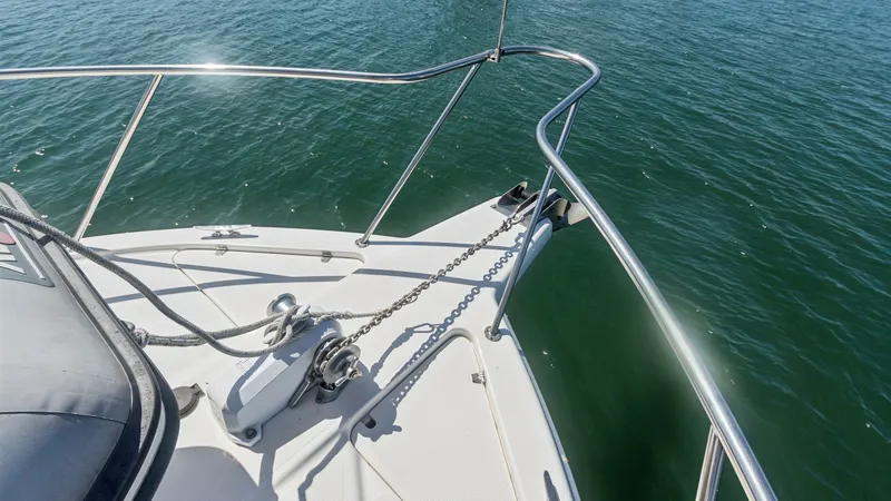 Slide: The Image of Bow with Anchor System and Rails This image showcases the bow of the 1998 Riviera Convertible yacht 'FOREVER YOUNG,' featuring a robust anchor system. Stainless steel rails provide safety and style, while the clean deck design offers ease of movement and functionality. The view highlight - 7415863