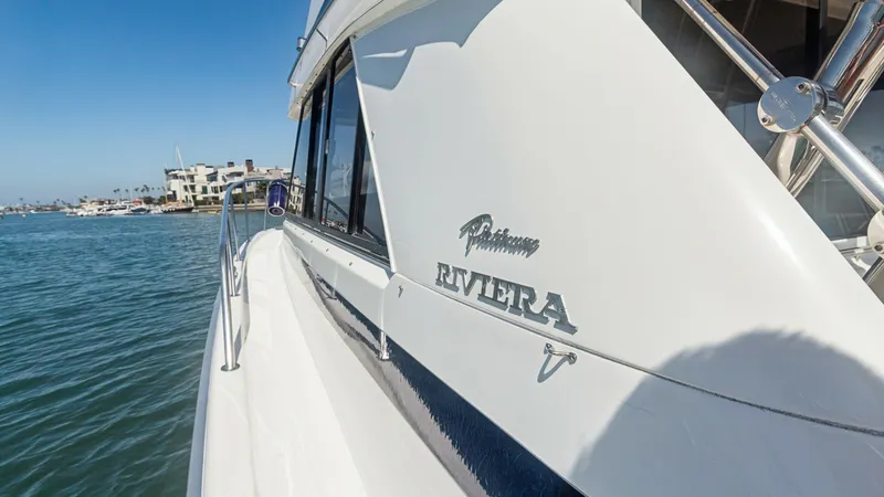 Slide: The Image of Starboard Side Walkway View This image showcases the sleek starboard side walkway of the 1998 Riviera Convertible, FOREVER YOUNG. The polished stainless steel railings and expansive side deck provide secure and comfortable passage. The manufacturer's emblem prominently displayed enh - 7415864
