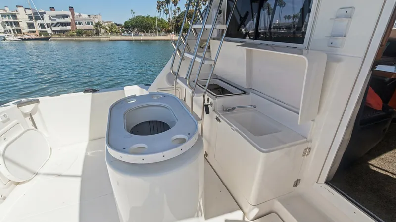 Slide: The Image of Cockpit with Tackle Station The cockpit of the 1998 Riviera Convertible features a well-equipped tackle station, perfect for avid anglers. This space includes a sink, storage compartments, and easy access to the flybridge via the sturdy ladder. The open layout offers ample room for - 7415862