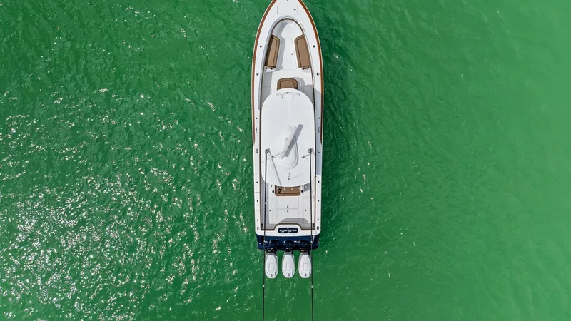 Slide: The Image of Aerial View of Bow and Deck This stunning aerial shot showcases the sleek deck layout of the 2024 Valhalla Boatworks V-37, highlighting its spacious bow area. The white hull contrasts beautifully with the vibrant green water, while the triple outboard engines at the stern hint at it - 7471218