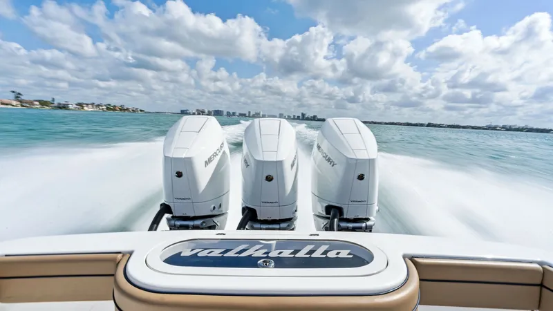 Slide: The Image of Triple Outboard Engines in Action This dynamic view captures the powerful triple outboard engines of the 2024 Valhalla Boatworks V-37, propelling the vessel with exceptional speed and efficiency. The sleek design and branding on the engines reflect the boat's cutting-edge engineering and - 7471178
