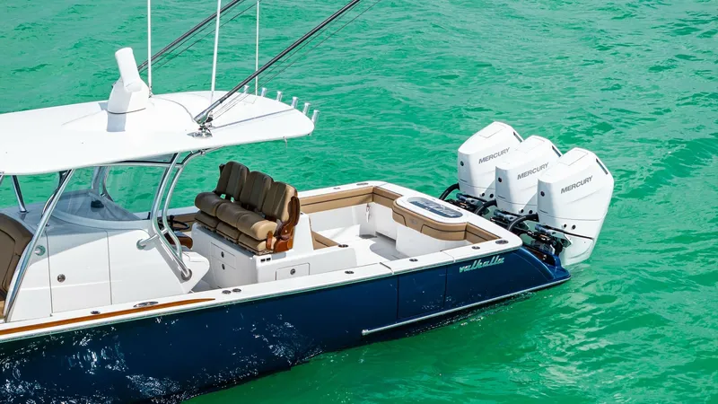 Slide: The Image of Aft Deck with Outboard Motors The Valhalla V-37 showcases a spacious aft deck equipped with triple Mercury outboard motors, offering impressive power and performance. The seating arrangement is optimized for comfort, featuring plush, well-cushioned seats that are ideal for relaxation - 7471223
